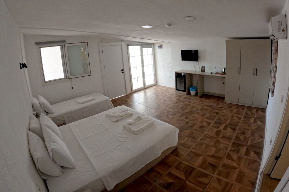 Habitación triple Deluxe, patio, vista al mar | Minibar, tabla de planchar con plancha y wifi gratis