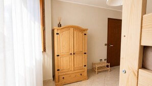 Une pièce avec une armoire en bois, une petite étagère en bois et une porte.