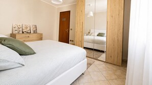 Une chambre à coucher comprenant un lit, une table de chevet et une armoire avec un miroir.