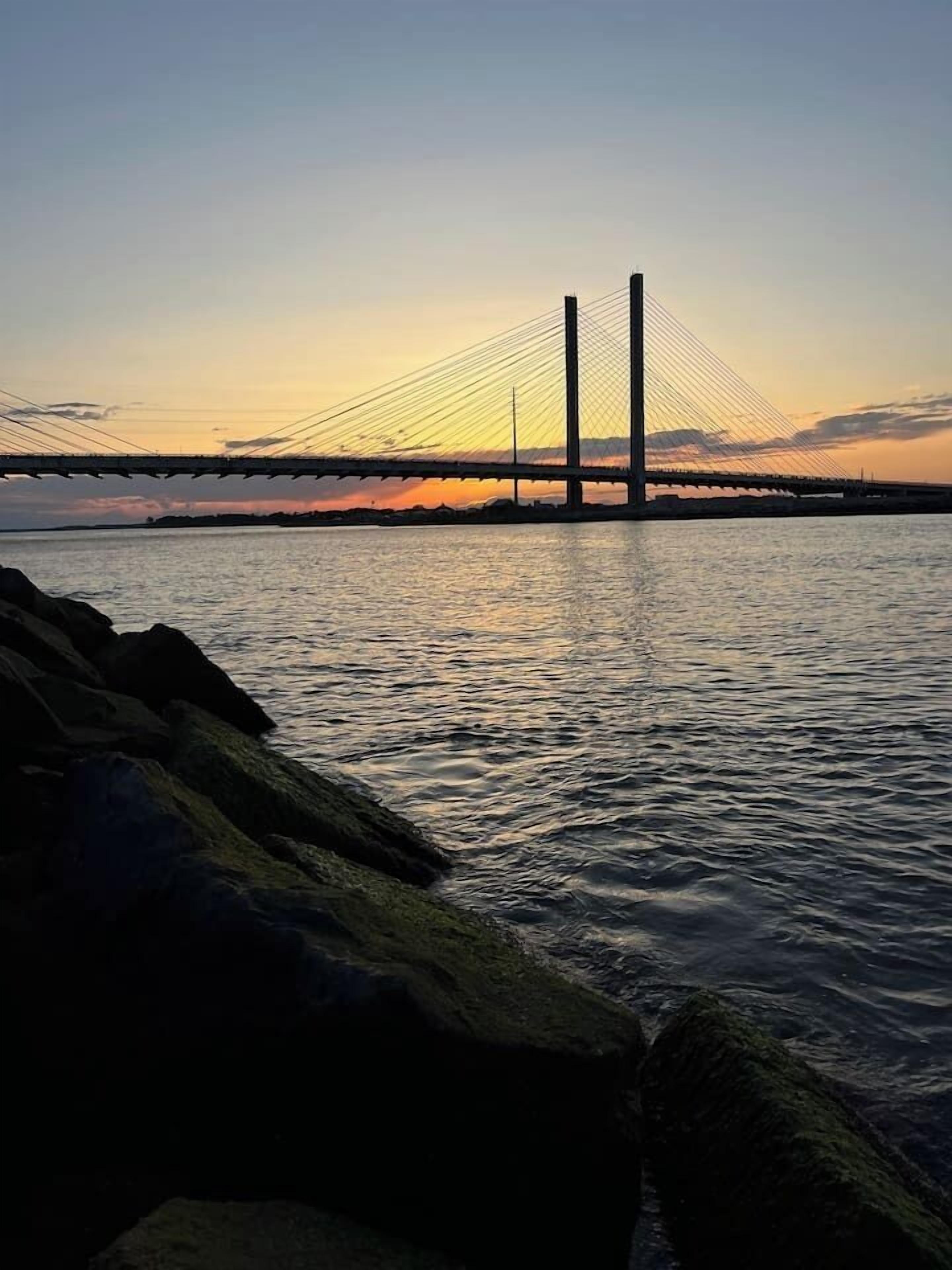 Un pont enjambant une étendue d’eau, avec un premier plan rocheux.