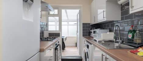 A modern kitchen with white cabinets, a stainless steel sink, and a view to the outside.