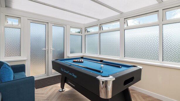 A pool table in a room with large windows and a blue sofa. - Contractor Stay | Parking & Fast Wi-Fi | Sleeps 4 (Barton Seagrave)
