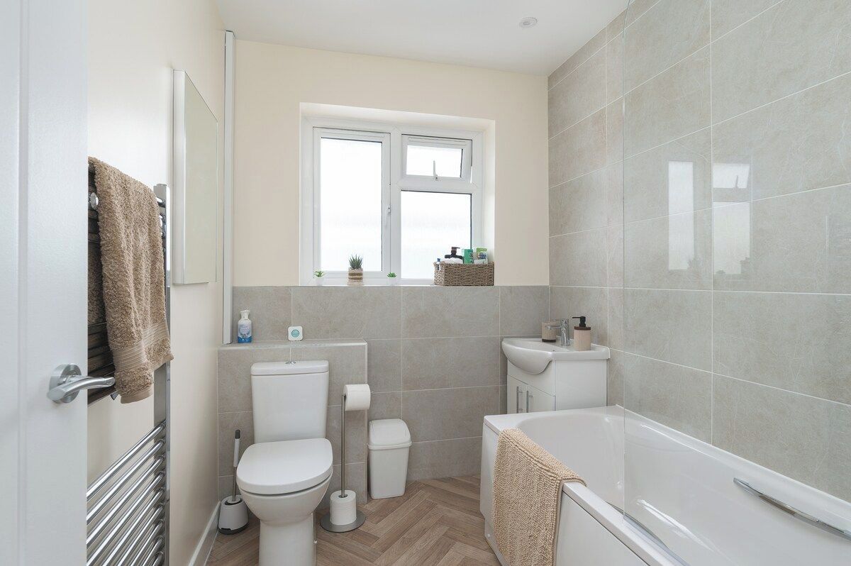 A compact bathroom with a toilet, bidet, and bathtub.