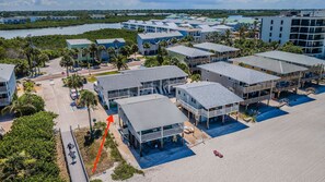 A coastal hotel with multiple-story buildings, a beachside location, and a parking area. - Directly on the beach. Newly remodeled Beachfront Bungalow with perfect beach views (Indian Shores)