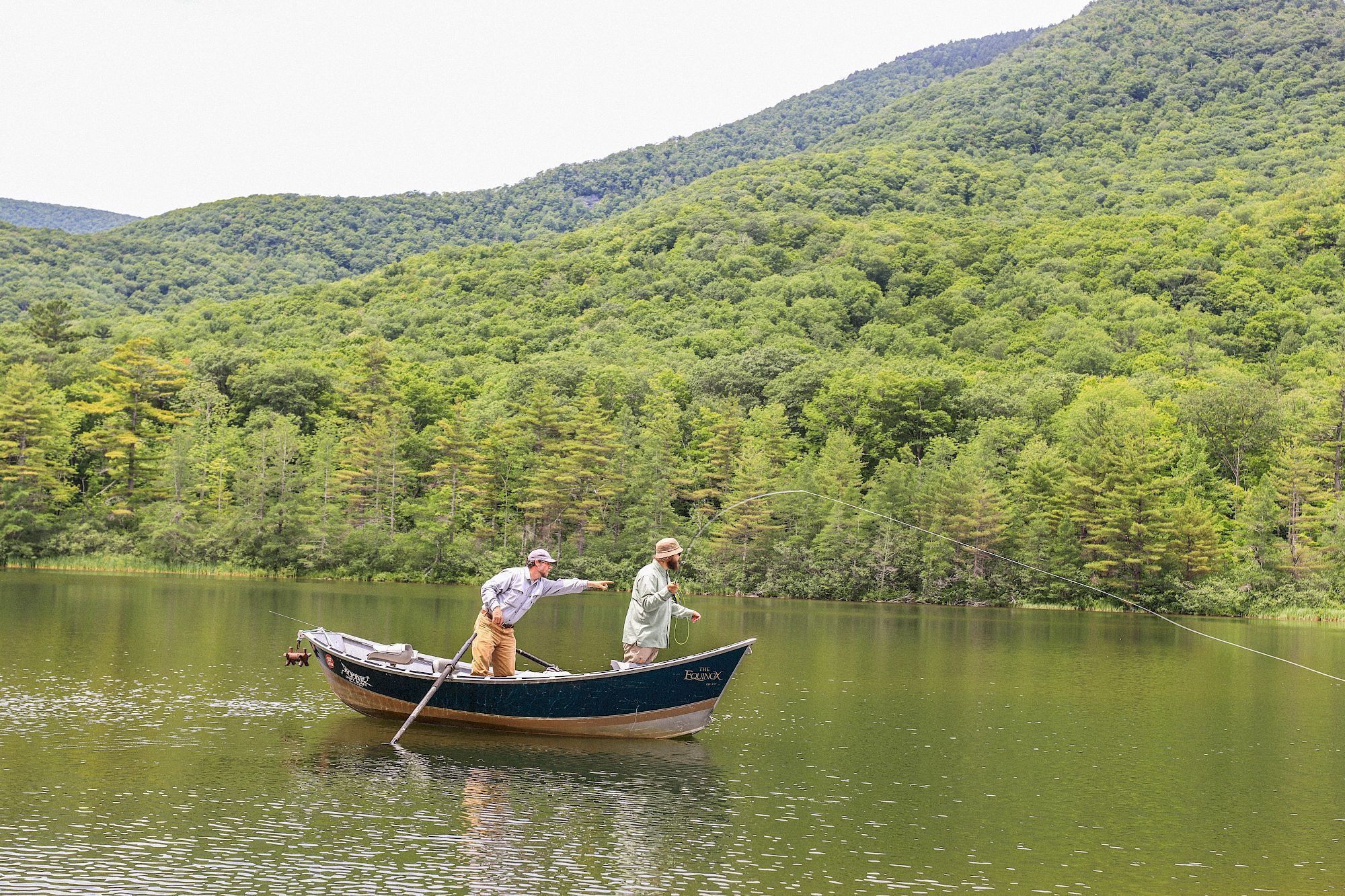 A boat on a calm lake surrounded by lush greenery.