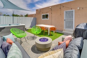 Eine Terrasse mit Grill, Sitzgelegenheit und überdachtem Tisch.