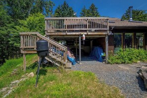 Ein zweistöckiges Holzhaus mit überdachter Veranda und einem Schotterweg.