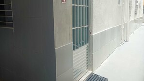 A building exterior with a door marked 'A', a window with vertical bars, and a metal grate at the entrance.