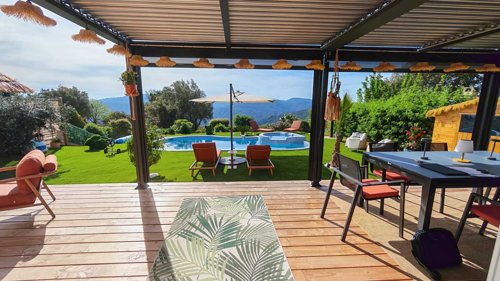 Un espace extérieur abrité comprenant une piscine, des chaises longues et une table.