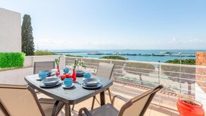 A table set for dining with a view of the sea and boats. - Oceanfront House, BBQ, Central Location, Easy Parking, Wi-Fi, Very Spacious (Roses)