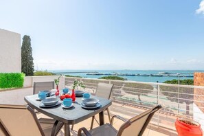 A table set for dining with a view of the sea and boats. - Oceanfront House, BBQ, Central Location, Easy Parking, Wi-Fi, Very Spacious (Roses)