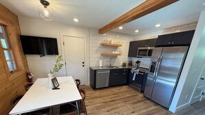 Eine moderne Küche mit Einbau-Mikrowelle, Edelstahlkühlschrank und Holzausstattung.