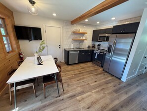 A modern kitchen with a built-in microwave, stainless steel refrigerator, and wooden cabinets.