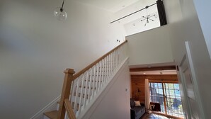 Eine Treppe mit Holzgeländern und freiem Blick auf die darüberliegende Etage.