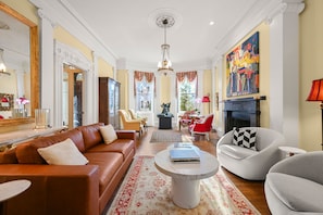 Un salon spacieux avec un canapé en cuir marron, une table basse ronde et une cheminée.