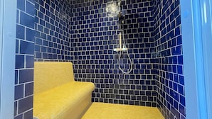 A small, enclosed shower area with blue-tiled walls and a yellow bench. - Suite with Balneotherapy—Marrakech Theme (Eaunes)