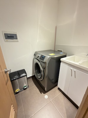 A laundry room with a washing machine, a sink, and a trash bin. - Alcalá Park - Cedritos, Bogotá (Bogotá)