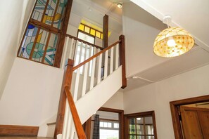 Eine Treppe mit Holzwerteln und einem Glasfenster mit Buntglas.