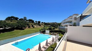 Ein modernes Hotel mit Pool, Blick auf die Landschaft und einem gepflegten Rasen.