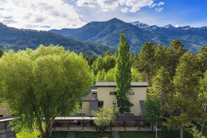 Ein Gebäude mit flachem Dach, einer überdachten Terrasse und Blick auf Berge.