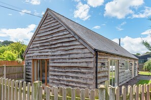 A wooden cabin with a sloped roof, a wooden fence, and a clear sky. - Charming Countryside Barn | Rural Shropshire - Pass the Keys (Newport)