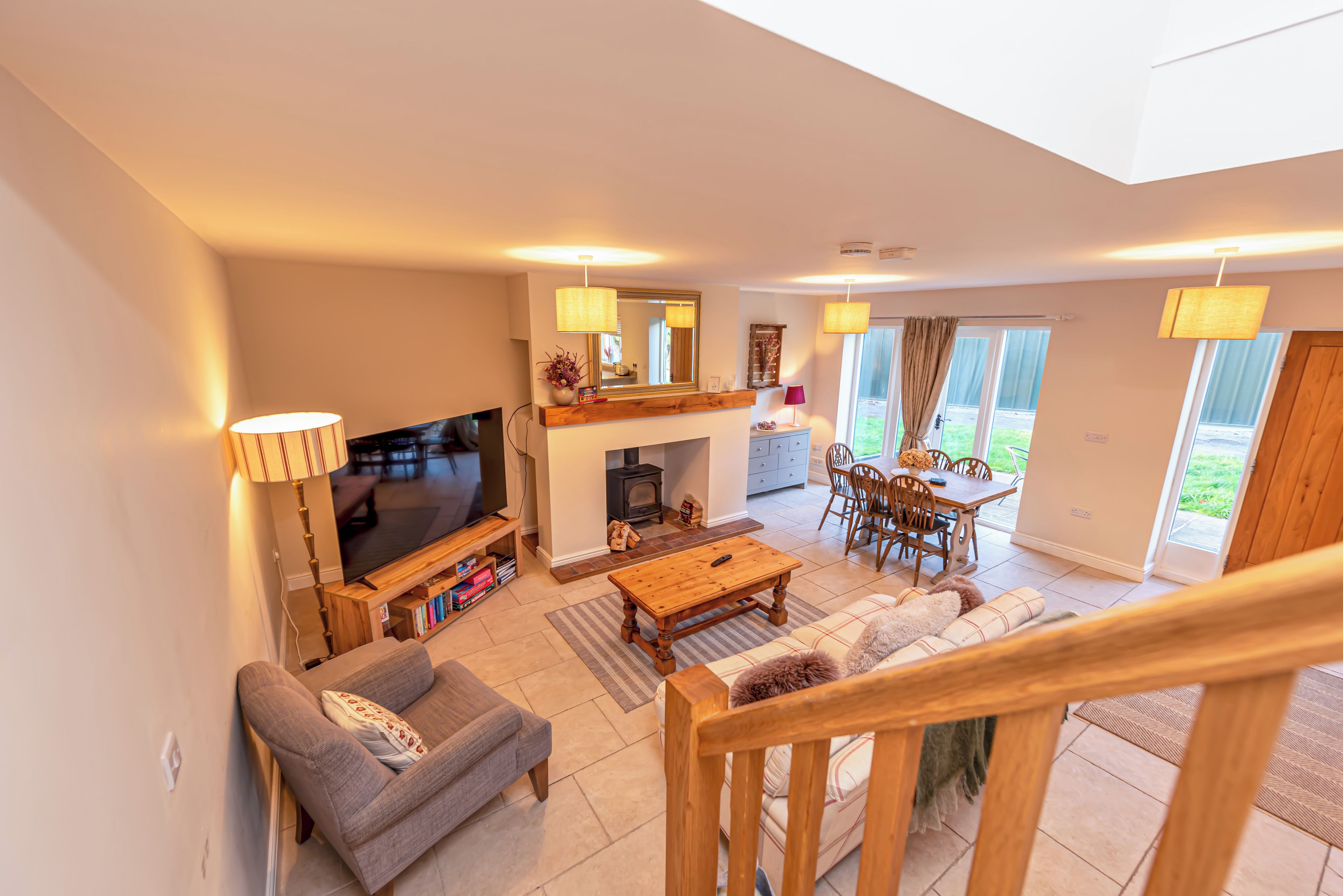 A modern living room with a flat-screen TV, sofa, coffee table, and a fireplace.