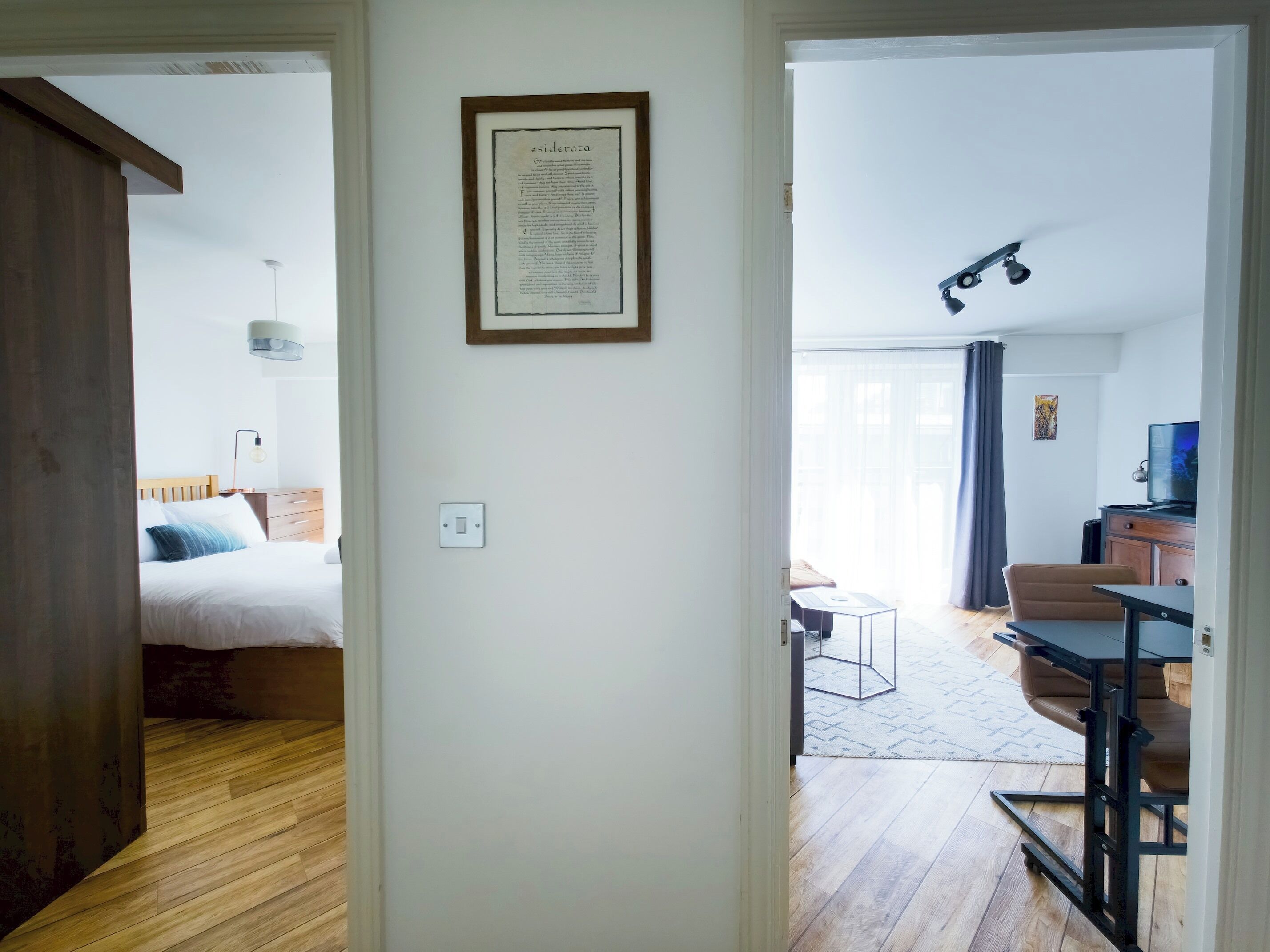A room with a bed, a desk, a chair, and a television.