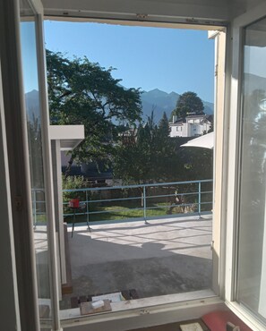 Ein Balkon mit Bergblick, einem Geländer und einem Stuhl.