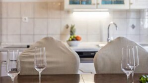 A modern kitchen with white cabinets, a sink, and a countertop with a bowl of fruit. - Four Bedroom Villa with Outdoor Pool (Studenci)