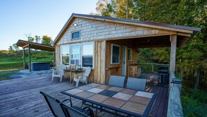 A wooden cabin with a deck, outdoor seating, and a covered patio area. - Romantic Private Cabin Getaway with Hot Tub and Scenic Views (Deansboro)