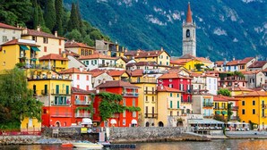 A coastal town with colorful buildings, a church tower, and a waterfront with boats. - Frenk House above Varenna (Lombardia)