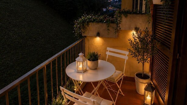 A terrace with a table and chairs, potted plants, and a view of the surrounding landscape. - Frenk House above Varenna (Lombardia)