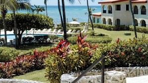 Ein Resort mit Palmen, einem Pool und einem Gebäude mit rotem Dach.