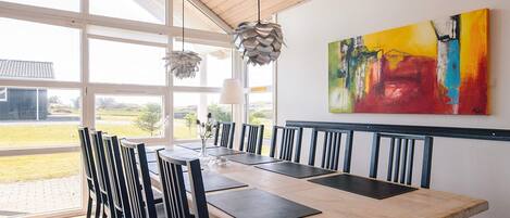 A dining area with a wooden table, black chairs, and a large window with a view of the outside.