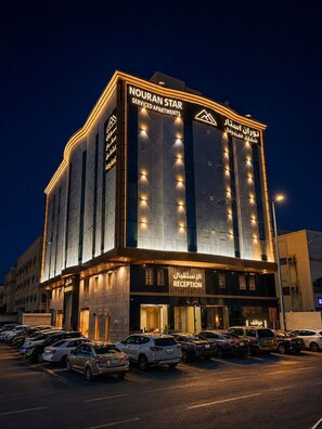 A modern building with 'NOURAN STAR' signage, a reception area, and a parking lot. - Nuran Star Serviced Apartments An Nuzhah (Jeddah)