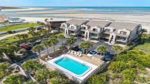Un resort con piscina, vista al mar y varias construcciones.