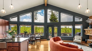 Un intérieur spacieux comprenant une grande cuisine, un coin repas et un salon confortable avec vue sur l’extérieur.