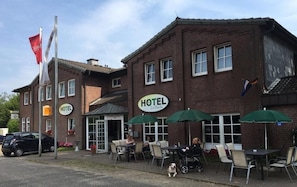 Un hotel con terraza, una bandera y un letrero que dice 'HOTEL Zur Buche'.