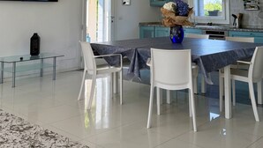 A modern kitchen with a dining area, a large window, and a painting on the wall. - Pool & Garden Villa Lelia (Veneto)