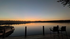 A calm lake at dusk with a dock and chairs on the wooden deck. - All Sports Lakefront Sunset w/Deck, Firepit, Dock (Ortonville)