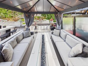 An outdoor seating area with two sofas, a table, and potted plants. - Luxury 3BR Townhome with Garden Oasis (Victoria)
