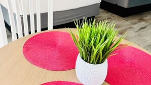 Una habitación con dos camas, una mesa con una planta y obras de arte en las paredes.