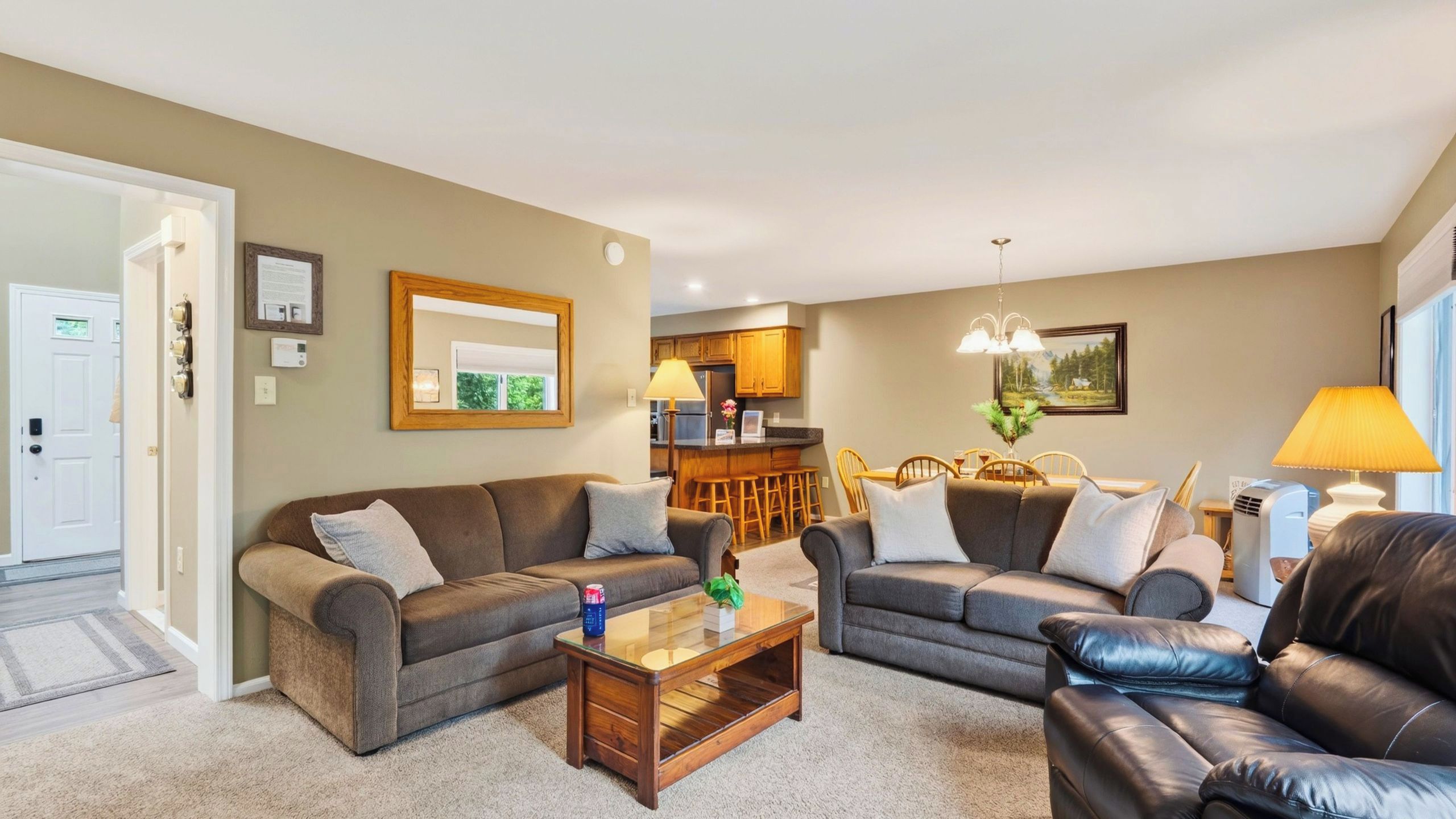 A living room with two sofas, a coffee table, and a dining area with a table and chairs.