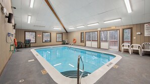 An indoor swimming pool with clear poolside areas, safety equipment, and exit signs. - Fox Lair by Avantstay Oversized Jetted Tub + Grilling Deck Heated Pool + Recreation Center (North Creek)