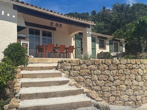 A house with a stone staircase leading to a patio with outdoor furniture. - Le Joyau, a gem with magnificent views (Tourtour)
