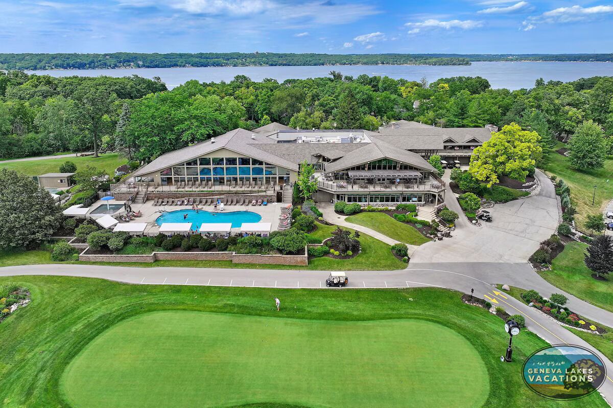 Un gran resort con piscina, campo de golf y vistas a un lago.