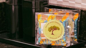 Una encimera de cocina con una cafetera, un hervidor y un paquete de cápsulas de café.