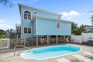 A two-story house with a swimming pool, a wooden deck, and a fenced patio area. - NEW! Emerald Isle 2nd-Row Luxury 5BR/5+BA Home w/ Pool, Hot Tub & Ocean Views (Emerald Isle)