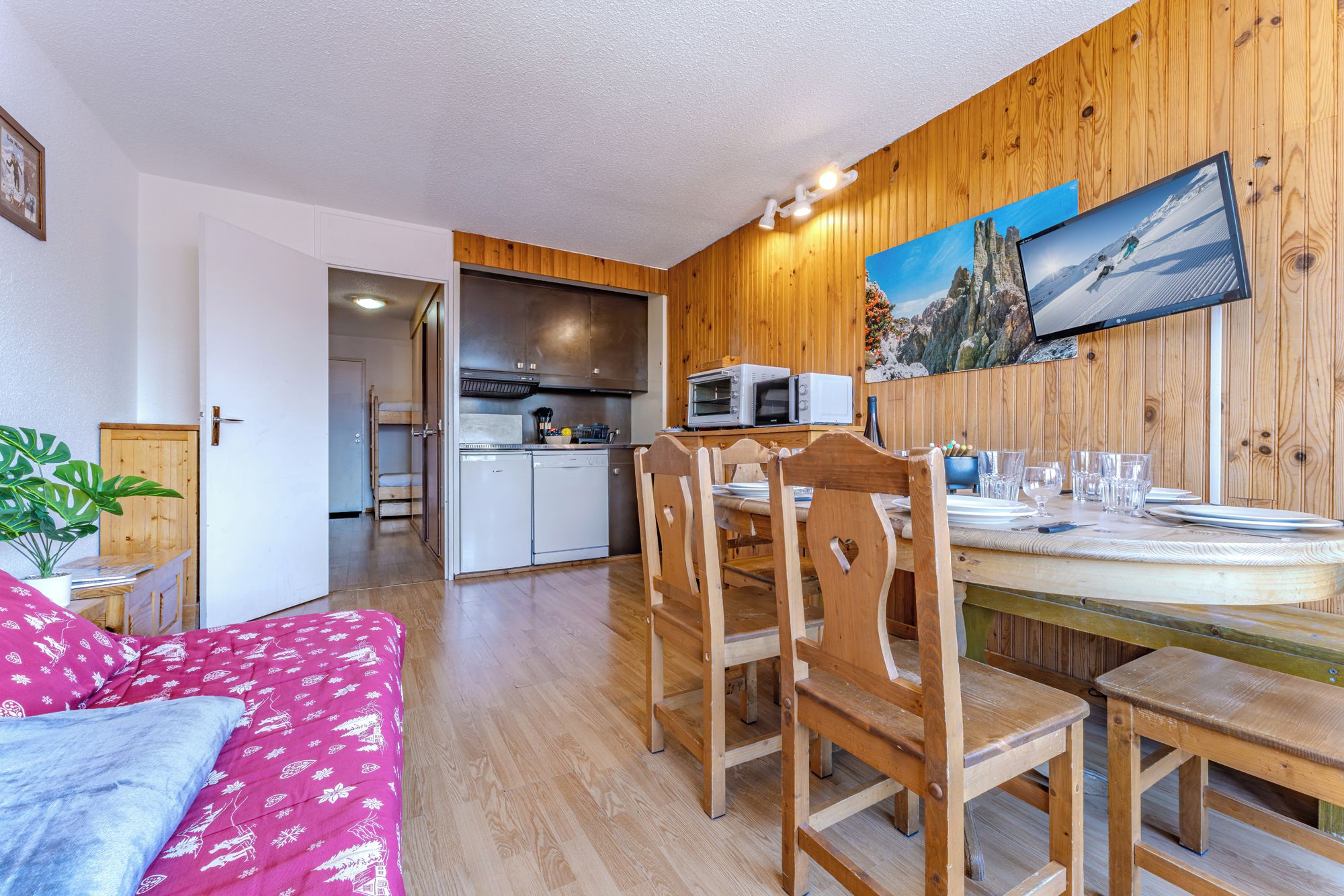 A compact living space with a kitchenette, dining area, and a cozy seating area.