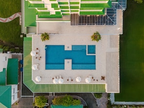 An aerial view of a hotel with a large swimming pool, outdoor seating, and a green roof. - Come Stay at This Beautiful Studio for Stunning Views of the Pacific Coastline! (Telire)